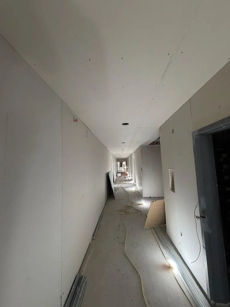 Custom framed feature wall with pot lights and HVAC ductwork before drywall